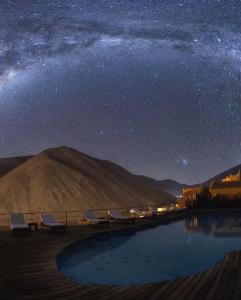 a starry night with a swimming pool in the desert at Cabañas Miraelqui in Pisco Elqui