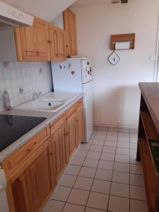 a kitchen with a sink and a refrigerator at Appartement Le Parad'hiver in Gérardmer +2 photos