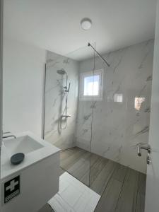 a white bathroom with a shower and a sink at Tides proprety - Medium Tide in Paul do Mar