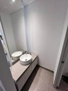 a white bathroom with a sink and a toilet at Loft de lujo barranquilla 3Pax in Barranquilla