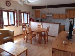 a kitchen and dining room with a wooden table and chairs at Appartement Le Parad'hiver in Gérardmer