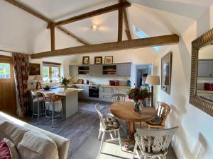 a kitchen and living room with a table and chairs at The Clock Tower & The Dairy - Two x 2 Bed Barns with Indoor Pool in Checkendon