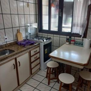 a kitchen with a stove and a table and stools at Canto de paz in Brusque