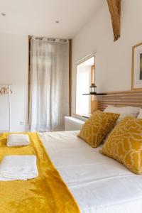a bedroom with two beds with yellow sheets and a window at La Petite Cour in Villiers-sous-Grez
