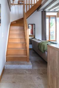 a staircase in a room with a bed and a couch at La Petite Cour in Villiers-sous-Grez