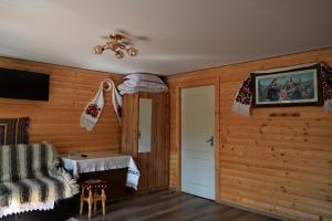 un soggiorno con pareti in legno e lampadario pendente di Casa Vladicu a Breb