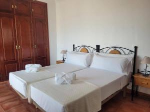 a bedroom with two beds with white sheets and wooden cabinets at Nerja Villas Tamango Hill 9 Silhouse in Torrox