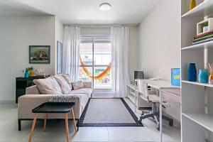 a white living room with a couch and a desk at WI-FI 100mb | Vista Parcial do MAR #CA32 in Florianópolis +28 photos