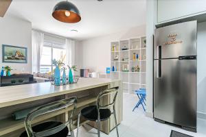 a kitchen with a stainless steel refrigerator and a table at Churrasqueira | Vista parcial do MAR #CA32 in Florianópolis