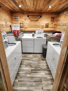 a kitchen with white appliances and wooden walls at Cabin in Butler