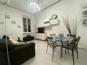 ein Wohnzimmer mit einem Sofa und einem Tisch mit Stühlen in der Unterkunft Casa Delle Sirene 5 minuti mare Boccadasse in Genua