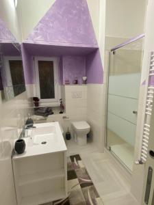 ein Badezimmer mit einem Waschbecken, einem WC und einer violetten Decke in der Unterkunft Casa Delle Sirene 5 minuti mare Boccadasse in Genua