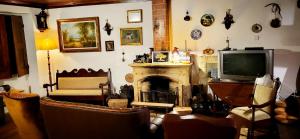 a living room with a television and a fireplace at Casa da Avó in Armamar