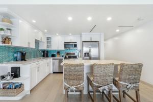 a kitchen with white cabinets and a table with chairs at Villas of the Galleon #6 in Seven Mile Beach