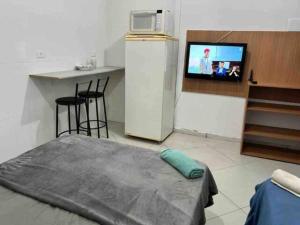 a room with a bed and a tv and a counter at Studio Aconchegante Ao lado Expo Center Norte SP in São Paulo