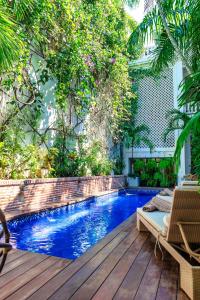 a swimming pool in a backyard with a wooden deck at Cartagena Old City Mansion in Cartagena de Indias