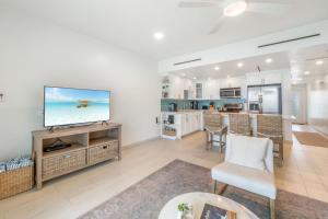 a living room with a tv and a kitchen at Villas of the Galleon #6 in Seven Mile Beach