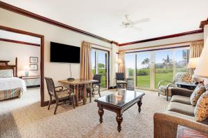 a hotel room with a bed and a living room at Waipouli Beach Resort H105 in Kapaa