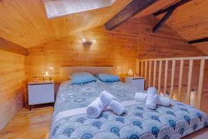 ein Schlafzimmer mit einem Bett in einer Hütte in der Unterkunft Le Chalet Gîte de Dordogne in Saint-Pardoux-la-Rivière