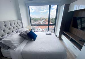 een groot bed in een kamer met een groot raam bij Apartaestudios modernos y exclusivos en Bogotá in Bogota