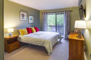 a bedroom with a bed and a window at Walk to Slopes! Pet-Friendly Beech Mtn Condo in Beech Mountain