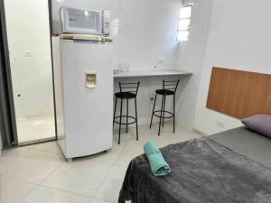 uma cozinha com um frigorífico e um balcão com bancos em Estudio na Vila Guilherme Ao lado Expo Center Norte em São Paulo