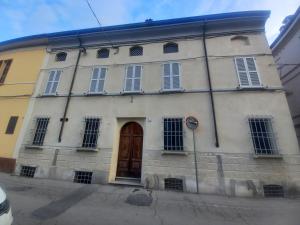 an old white building with a brown door at Console Camprini Estates - Faenza Apartments 2 in Faenza