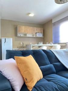 um sofá azul com almofadas na sala de estar em Apartamento Inteiro Completo 2 Quartos com AC em Blumenau SC à 10min Vila Germânica em Blumenau