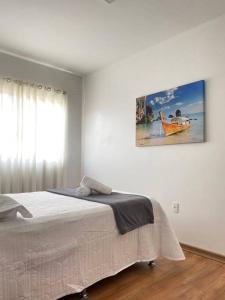 um quarto com uma cama e um quadro na parede em Apartamento Inteiro Completo 2 Quartos com AC em Blumenau SC à 10min Vila Germânica em Blumenau