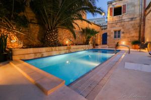 a swimming pool in front of a building at Ta' Matmura B&B in Għarb