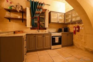 a kitchen with green cabinets and a stove top oven at Ta' Matmura B&B in Għarb
