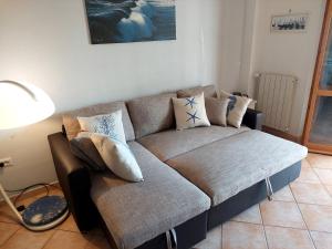 un canapé avec des coussins dessus dans un salon dans l'établissement Appartamento vista mare, 100mt dall'Ospedale Pediatrico, a 200mt dal mare, 1h da Roma Termini, à Santa Marinella