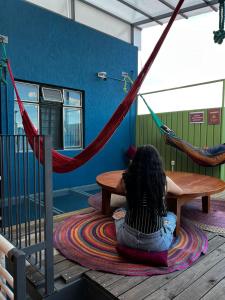 una donna seduta su un tappeto su un'amaca di HOSTAL CHOCOLATE CALENDA a Città di Oaxaca