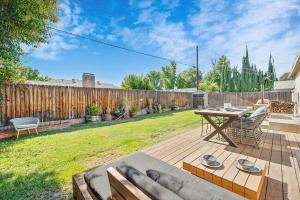a backyard with a wooden deck with a table and chairs at Charming 4 Bedroom Home W/ Large, Gated Backyard in Los Angeles