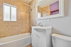 a bathroom with a sink and a toilet and a tub at Charming 4 Bedroom Home W/ Large, Gated Backyard in Los Angeles