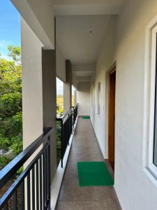 - un couloir d'une maison avec un tapis vert au sol dans l'établissement SanTrupthi A Stay at Home, à Chikmagalur