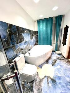 a bathroom with a toilet and a bath tub at Bierini Park Studio in Riga