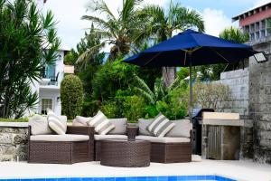 een patio met banken en een parasol naast een zwembad bij Sandpiper Apartments in Mount Pleasant