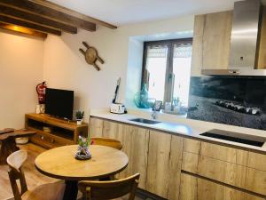 a kitchen with a table and a sink and a counter at Apartamentos Zabalarena Artzaia in Orbaiceta