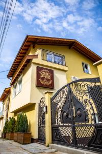 a yellow house with a black gate in front of it at Forest Oasis Guest House FREE PARKING in Sapareva Banya