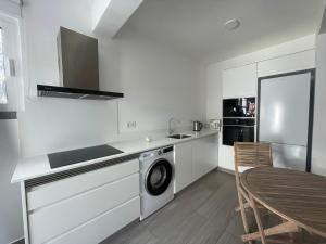 a kitchen with a washing machine and a table at Tides proprety - Low tide in Paul do Mar