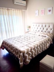 a large bed in a bedroom with a large window at Dpto Costanera in Corrientes