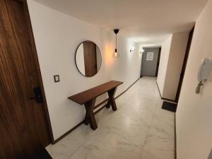 a hallway with a wooden table and a mirror at Asombroso Loft Moderno Con Excelente Ubicación in Mexico City