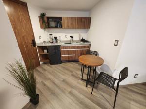 a kitchen with a table and chairs and a counter at Asombroso Loft Moderno Con Excelente Ubicación in Mexico City