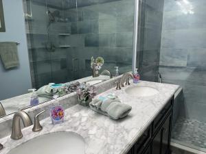 a bathroom with two sinks and a large mirror at Right Direction Rentals in Port Saint Lucie