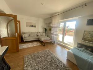 a living room with a couch and a large window at Apartament Olivia in Iaşi
