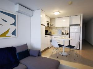 a living room with a couch and a table in a kitchen at TAMARAN (ENTRE YUMBO ET CITA) in Playa del Ingles