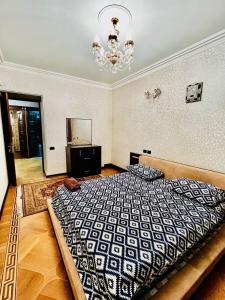 a bedroom with a large bed and a chandelier at Superb Central Location! Spacious and Comfortable 1 Bedroom + Jacuzzi, Next To Northern Avenue in Yerevan