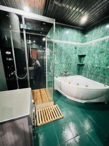 a green tiled bathroom with a tub and a shower at Superb Central Location! Spacious and Comfortable 1 Bedroom + Jacuzzi, Next To Northern Avenue in Yerevan