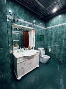 a green bathroom with a sink and a toilet at Superb Central Location! Spacious and Comfortable 1 Bedroom + Jacuzzi, Next To Northern Avenue in Yerevan